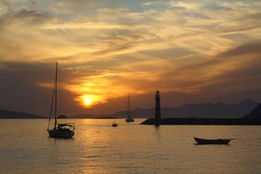 Gün batımında deniz manzarası. Sahildeki deniz feneri. Deniz kenti Turgutreis ve muhteşem gün batımları