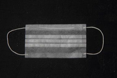 Tek kullanımlık tıbbi maske siyah arkaplanda izole edildi