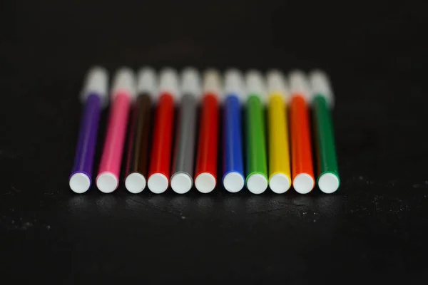 Multi-colored markers for drawing. Markers on a black isolated background