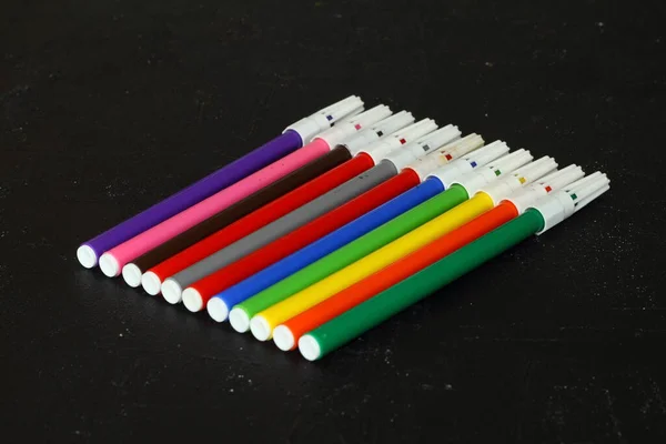 Multi-colored markers for drawing. Markers on a black isolated background