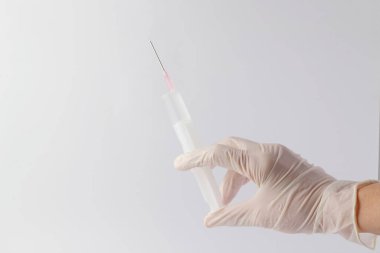 Doktorda iğnesi olan tıbbi plastik aşı ekipmanları ya da beyaz arka planda izole edilmiş hemşire eli. Sağlık hizmeti konsepti. El ele tutuşma şırıngası ve aşı. Şırınga izole edildi..