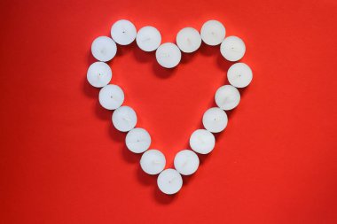  Kırmızı zemin üzerinde kalp şeklinde beyaz mumlar, Sevgililer Günü konsepti