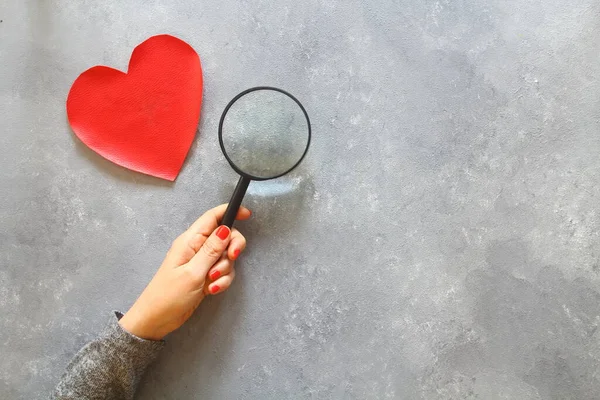 person holding magnifying glass and search love