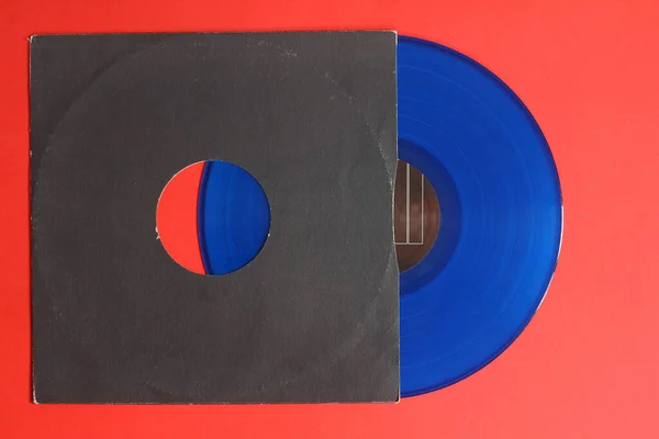 Alter Schwarzer Papiereinband Und Blaue Schallplatte Isoliert Auf Rotem Hintergrund — Stockfoto