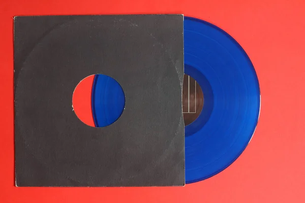 Kırmızı arkaplanda siyah kağıt kapağı ve mavi plak plağı izole edildi