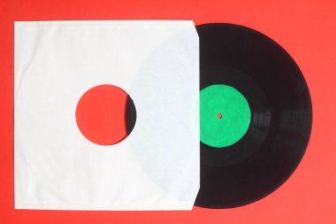 Kırmızı arkaplanda beyaz kağıt kapağı ve vinil LP kaydı izole edildi