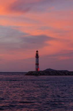 Gün batımında deniz manzarası. Sahildeki deniz feneri. Deniz kenti Turgutreis ve muhteşem gün batımları