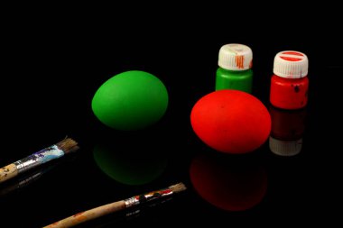 Paskalya yumurtalarını boyamak için boya ve fırçalı siyah masa.