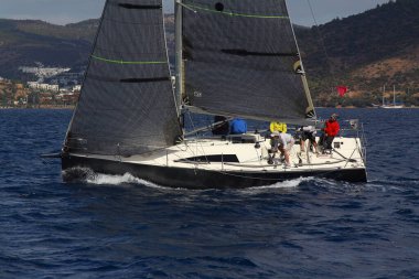 Bodrum, Hindi. 08 Ekim 2017: Denizdeki dalgalar arasında yelken açmak. Yelkenli tekneyi, yelkenliyi ya da yatı beyaz yelkenlilerle kapatın..