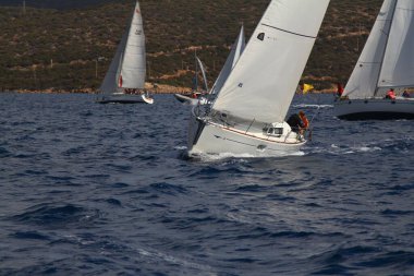 Bodrum, Hindi. 08 Ekim 2017: Denizdeki dalgalar arasında yelken açmak. Yelkenli tekneyi, yelkenliyi ya da yatı beyaz yelkenlilerle kapatın..