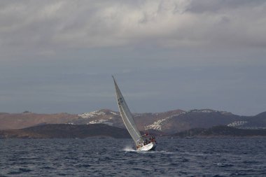 Bodrum, Hindi. 08 Ekim 2017: Denizdeki dalgalar arasında yelken açmak. Yelkenli tekneyi, yelkenliyi ya da yatı beyaz yelkenlilerle kapatın..