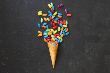 Siyah arka planda renkli şekerli dondurma külahının en üst görüntüsü