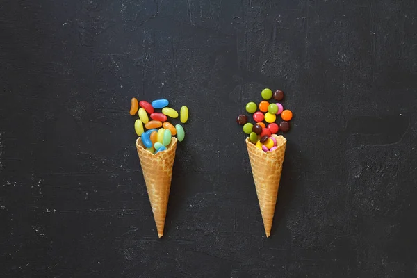 Siyah arka planda renkli şekerli dondurma külahının en üst görüntüsü
