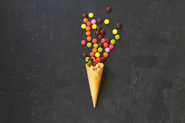 Siyah arka planda renkli şekerli dondurma külahının en üst görüntüsü