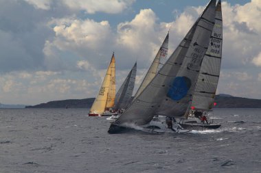 Bodrum, Hindi. 09 Aralık 2017: Yelkenliler Ege Denizi 'nin mavi sularında, ünlü tatil beldesi Bodrum' un kıyılarında rüzgarlı havada yelken açıyor.