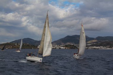 Bodrum, Hindi. 10 Aralık 2017: Yelkenliler Ege Denizi 'nin mavi sularında, ünlü tatil beldesi Bodrum' un kıyılarında rüzgarlı havada yelken açıyorlar..
