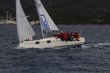 Bodrum, Türkiye. 10 Aralık 2017: Ünlü tatil beldesi Bodrum 'un kıyılarında, Ege Denizi' nin mavi sularında rüzgarlı havada yelken açan yelkenliler.