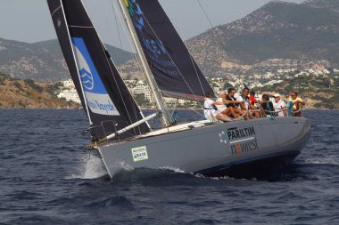 Bodrum, Türkiye. 17 Ekim 2020: Bodrum 'un ünlü tatil beldesi Bodrum' un kıyılarında, Ege Denizi 'nin mavi sularında rüzgarlı havada yelken açan yelkenliler.