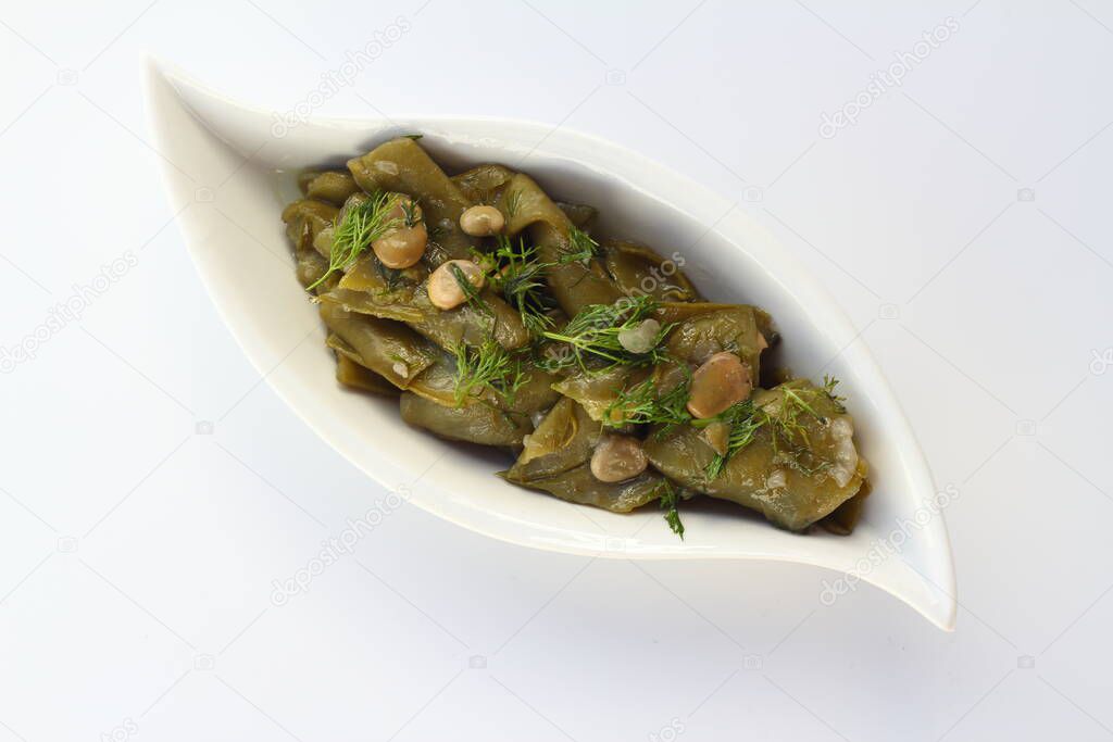 Broad bean and dill in the white plate with white background.