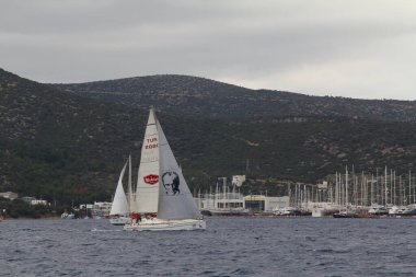 Bodrum, Türkiye. 20 Ocak 2018: Bodrum 'un ünlü tatil beldesi Bodrum' un kıyılarında, Ege Denizi 'nin mavi sularında rüzgarlı havada yelken açan yelkenliler.