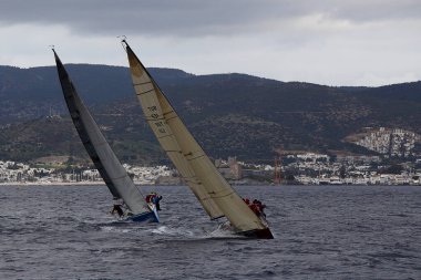 Bodrum, Türkiye. 20 Ocak 2018: Bodrum 'un ünlü tatil beldesi Bodrum' un kıyılarında, Ege Denizi 'nin mavi sularında rüzgarlı havada yelken açan yelkenliler.