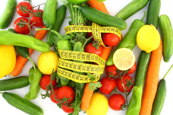 带测量带的饮食概念 白色背景的新鲜蔬菜 胡萝卜 欧芹和黄色的测量带 — 图库照片