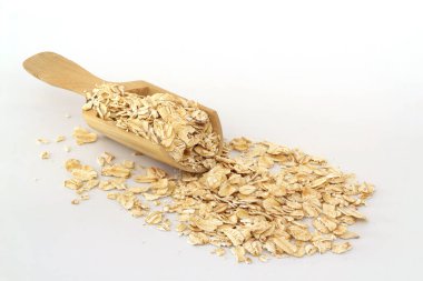 Beyaz arka planda izole edilmiş tahta kaşıkta yulaf ezmesi. Yulaf ezmesi veya tahıl gevreği paketi için bir yığın yulaf.