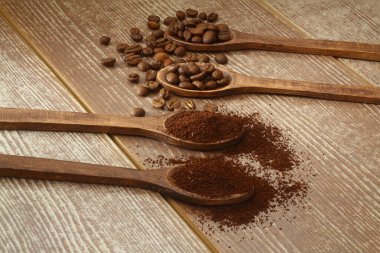 Kahverengi arka planda tahtadan kaşıklarla kahve ve kahve.