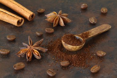 Kahve çekirdekleri, tarçın çubukları, anason ve tahta kaşık yakın plan.