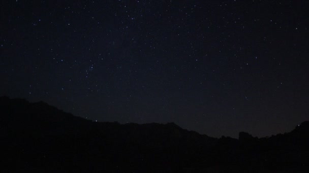 Gece Gökyüzünde Hareket Eden Yıldızların Zaman Çizelgesi Önünde Bir Dağ — Stok video