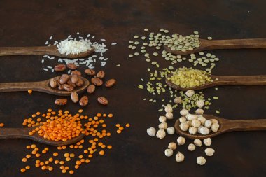 Farklı türde ham kuru baklagil kompozisyonu. Beyaz fasulye, mercimek, bulgur, nohut, böbrek fasulyesi, mısır, pirinç, organik bakla konsepti