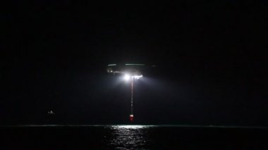 Gece görüşlü itfaiye helikopteri denizden su alıyor. Bodrum, Mugla- Türkiye