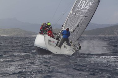 Bodrum, Türkiye. 11 Şubat 2018: Bodrum 'un ünlü tatil beldesi Bodrum' un kıyılarında, Ege Denizi 'nin mavi sularında rüzgarlı havada yelken açan yelkenliler.