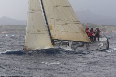 Bodrum, Türkiye. 11 Şubat 2018: Bodrum 'un ünlü tatil beldesi Bodrum' un kıyılarında, Ege Denizi 'nin mavi sularında rüzgarlı havada yelken açan yelkenliler.