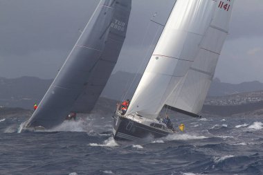 Bodrum, Türkiye. 11 Şubat 2018: Bodrum 'un ünlü tatil beldesi Bodrum' un kıyılarında, Ege Denizi 'nin mavi sularında rüzgarlı havada yelken açan yelkenliler.