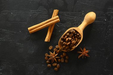 Tarçın çubukları ve anason yıldızları kavrulmuş kahve çekirdekleri üzerinde baharatlar. Tahta Çubukla.