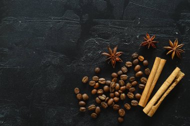 Tarçın çubukları ve anason yıldızları kavrulmuş kahve çekirdekleri üzerinde baharatlar..