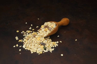 Sağlıklı kahvaltı. Ahşap kepçeyle karışık müsli. Paslı arka planda izole edilmiş.
