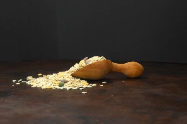 Sağlıklı kahvaltı. Ahşap kepçeyle karışık müsli. Paslı arka planda izole edilmiş.
