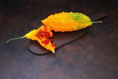 Momordica charantia paslı bir arka planda izole edilmiş. Momordica Charantia 'nın olgun meyveleri. Paslı arka planda acı kavun ya da acı kabak olarak da bilinir.