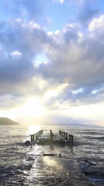 Deniz kenti Turgutreis ve muhteşem gün batımları. Bodrum, Hindi. Terk edilmiş eski iskelede. sosyal medya için dikey video.