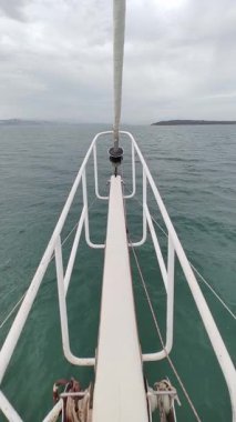 Denizde yüzen yelkenli teknenin pruvası. Sosyal medya için dikey video.