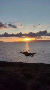 Deniz kenti Turgutreis ve muhteşem gün batımları. Bodrum, Hindi. Ege Denizi 'nin ortasında büyük bir kaya. sosyal medya için dikey video. 