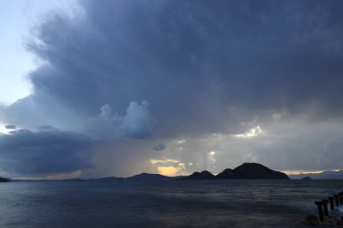 Okyanus üzerinde şiddetli, fırtına bulutları, bir fırtınanın gelişinin habercisi. Çok güzel aydınlatılmış kara bulutlar ve okyanus sularındaki yansımalar.