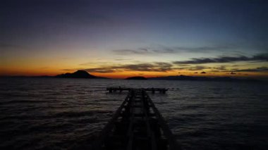 Sonbaharda Ege Denizi 'nde bulutlu bir günde onu dalgalardan korumak için terk edilmiş ve parçalanmış ahşap bir iskele. Zaman Uygulaması.