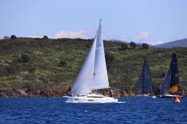 Bodrum, Hindi. 16 Mart 2024: Yelkenliler Ege Denizi 'nin mavi sularında, ünlü tatil beldesi Bodrum' un kıyılarında rüzgarlı havada yelken açıyorlar..