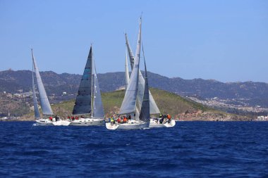 Bodrum, Hindi. 16 Mart 2024: Yelkenliler Ege Denizi 'nin mavi sularında, ünlü tatil beldesi Bodrum' un kıyılarında rüzgarlı havada yelken açıyorlar..