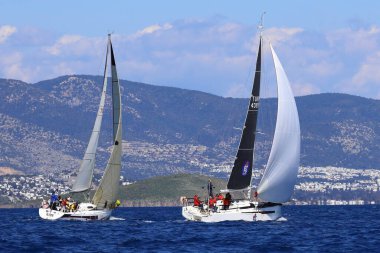 Bodrum, Hindi. 16 Mart 2024: Yelkenliler Ege Denizi 'nin mavi sularında, ünlü tatil beldesi Bodrum' un kıyılarında rüzgarlı havada yelken açıyorlar..