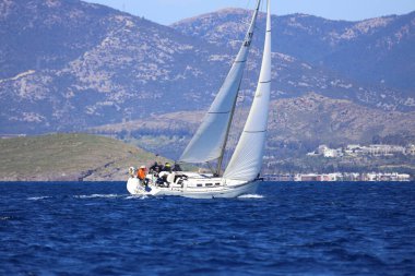 Bodrum, Hindi. 16 Mart 2024: Yelkenliler Ege Denizi 'nin mavi sularında, ünlü tatil beldesi Bodrum' un kıyılarında rüzgarlı havada yelken açıyorlar..