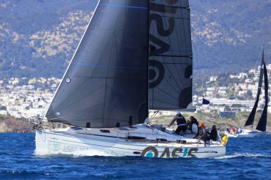 Bodrum, Hindi. 16 Mart 2024: Yelkenliler Ege Denizi 'nin mavi sularında, ünlü tatil beldesi Bodrum' un kıyılarında rüzgarlı havada yelken açıyorlar..